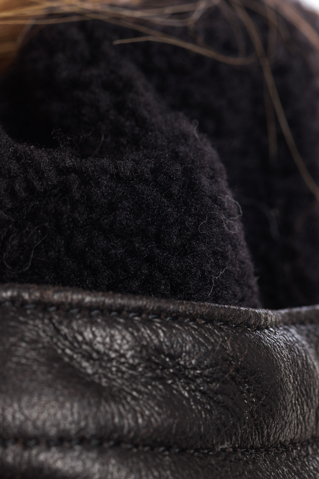 Bomber nero con cappuccio in montone a pelo lungo